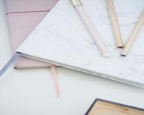 A notebook and pen on a clean, light-colored desk